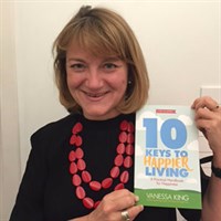 Vanessa King holding the 10 Keys to Happier Living book
