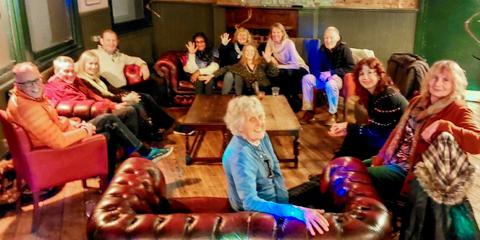A group of people sitting in a circle in a pub